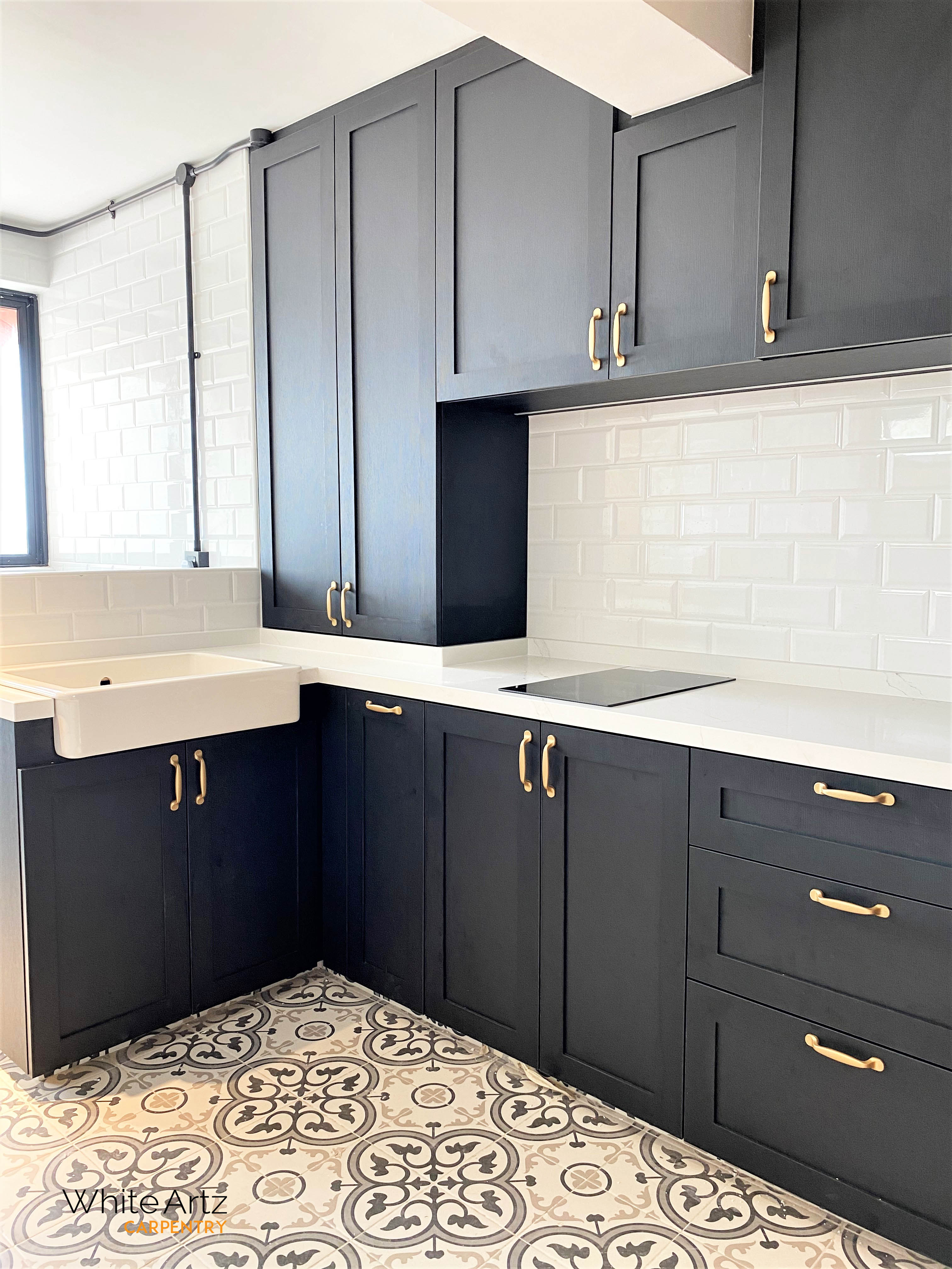 Modern black Shaker kitchen cabinets with a white quartz counter, contrasting white subway tile backsplash, and elegant gold-toned hardware.