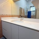 Modern white custom bathroom vanity unit with quartz countertop, undermount sink, and illuminated mirror LED strip lighting