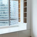 Custom white built-in bay window storage platform with LED display shelving by direct carpenter