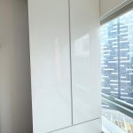 Custom glossy white full-height wardrobe integrated over bay window by direct carpentry Singapore